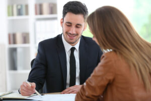 A lawyer sits at a desk with a client to explain Massachusetts’ maternity and parental leave laws.