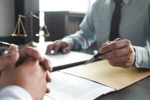 Lawyer sits across desk from client and explains the Massachusetts Wage Act guide