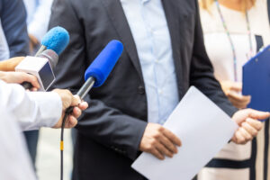 Closeup of microphones in front of a whistleblower reporting unlawful activity.