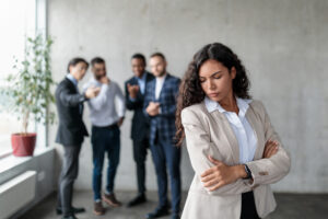 Woman in a white collared shirt being harassed, wondering if independent contractors can sue for discrimination.