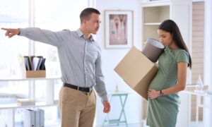 A manager orders a pregnant woman to pack up her belongings and leave the workplace office.